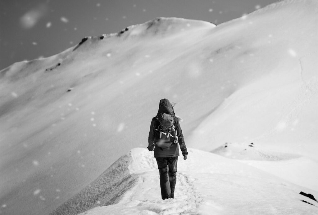 Woman climbing a mountain in the snow